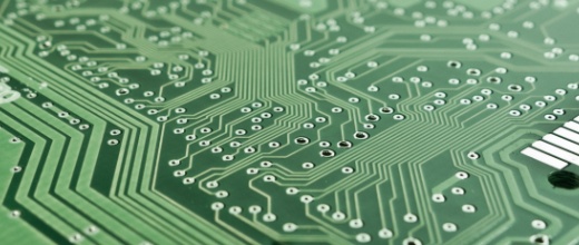 Close-up of a green circuit board with electronic traces.