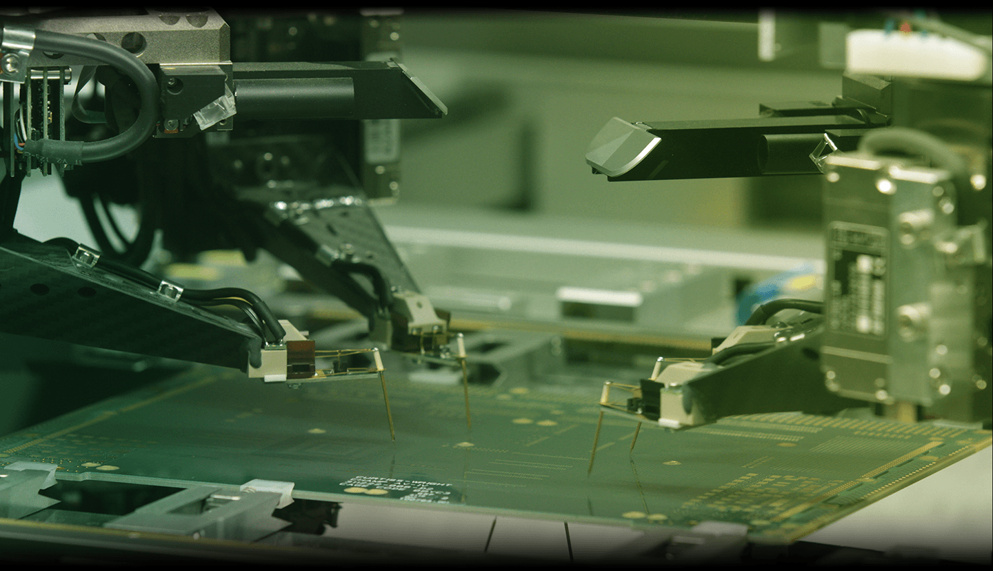 Automated machinery calibrating or testing a circuit board in a technology manufacturing setting.